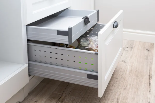 Kitchen cupboard with opened drawer and inner drawer inside