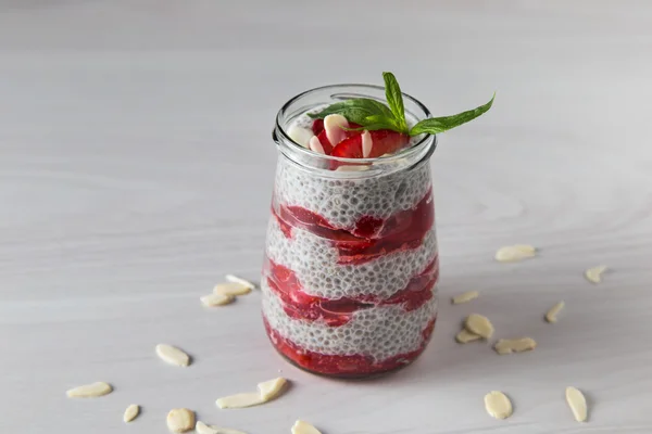 Raw vegan dessert: Chia seeds pudding with strawberries on a wooden background