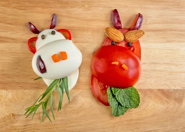 Healthy food. The figure of a cow made of vegetables and fruits on wooden board