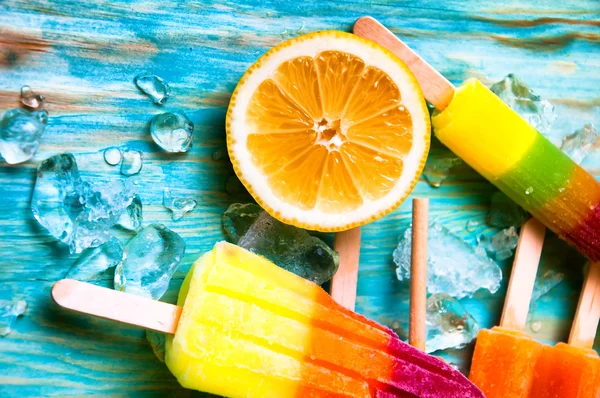Ice cream, juicy fruits and ice cubes on wooden background