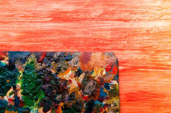 Painting palette on colored wooden background