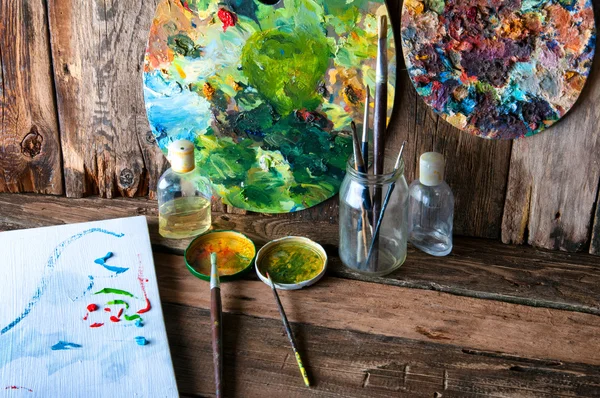 Palettes, brushes and canvas in an old painting workshop
