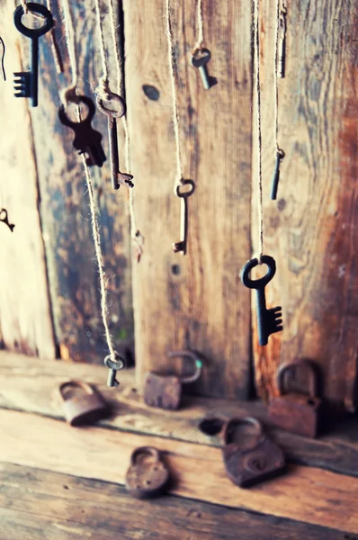 Many keys hanging on a string. Wooden background. Selective focus