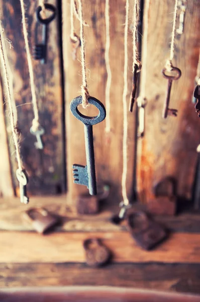 Many keys hanging on a string. Wooden background. Selective focus