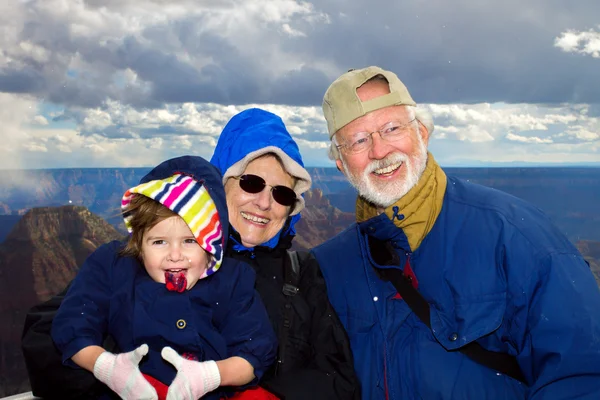 Happy Grandparents Hold Granddaughter  at the Grand Canyon