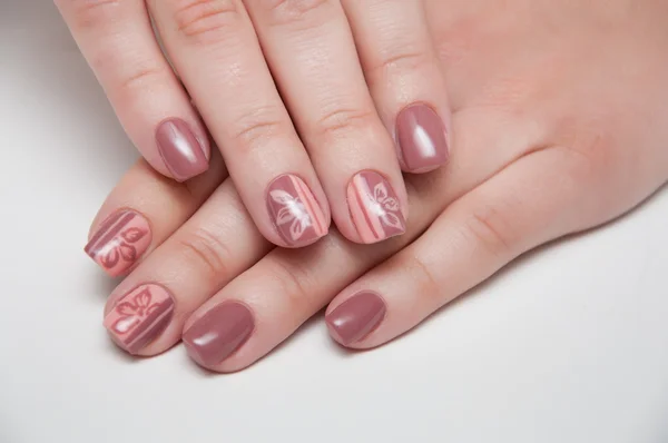 Beige manicure on a white background with short nails with flowers