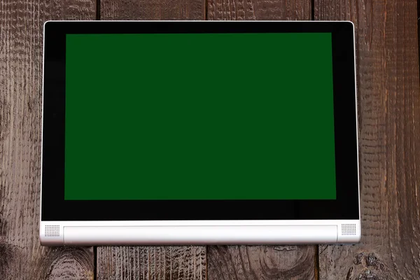 Tablet with isolated screen on the brown wooden table.