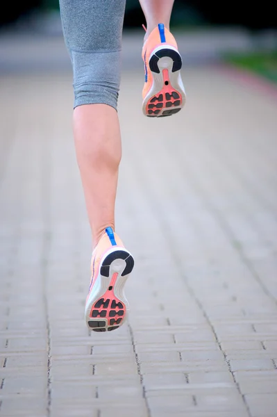 Feet of an athlete running on a park pathway training for fitnes