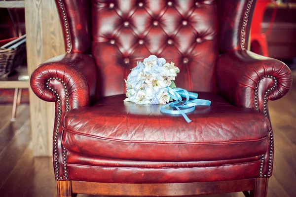 Bride\'s bouquet on a red armchair
