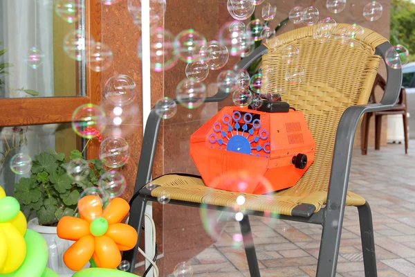 machine blowing bubbles standing on a chair