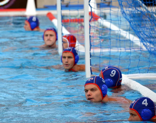 The russian waterpolo team at the goal line waiting for the start.