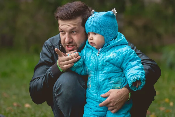 Happy family walking in autumn park: Adorable dad teaches young son