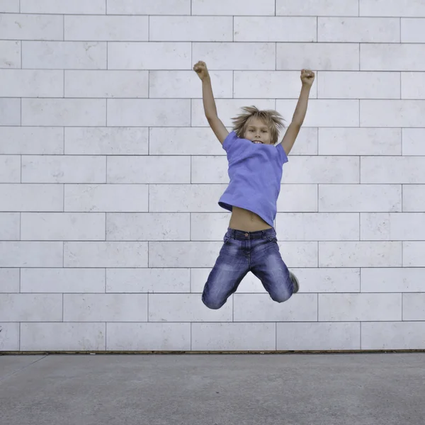 Happy little boy jumping in the city. People, childhood, happiness, freedom, movement concept