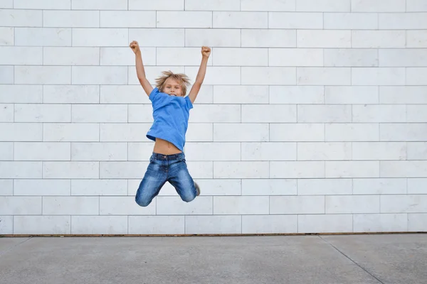 Happy little boy jumping in the city. People, childhood, happiness, freedom, movement concept