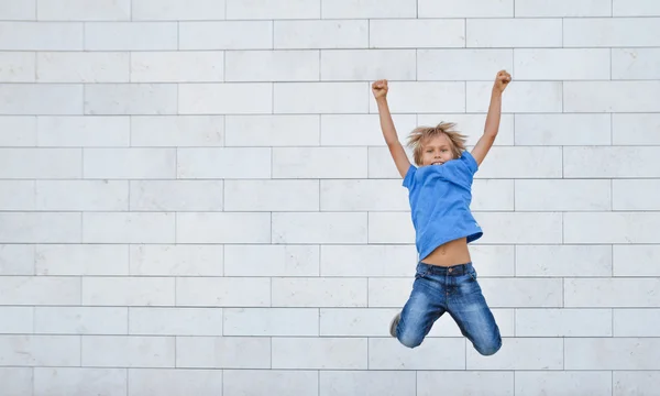 Happy little boy jumps on high. People, childhood, happiness, freedom, movement concept