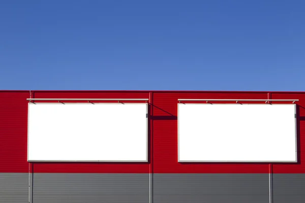Mock up. Empty horizontal billboards screens on the red wall against blue sky