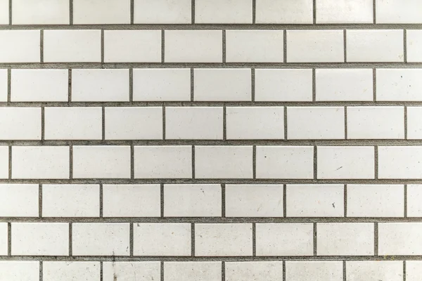 Dirty and grainy white gray tile city wall