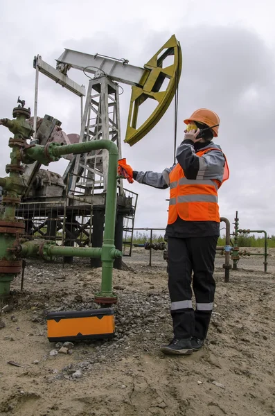 Woman engineer in the oil field repairing wellhead