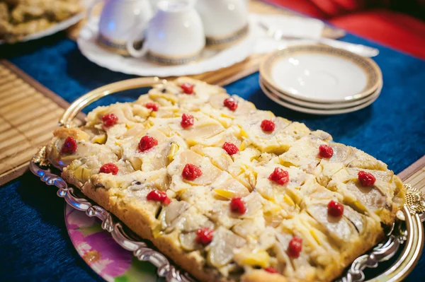 Home baked biscuit charlotte. Delicious freshly baked gingerbread sweet cake with apples. served on a table in a golden platter, cut square pieces.