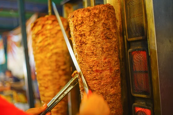 Chef\'s arm moving to cut a doner kebab meat
