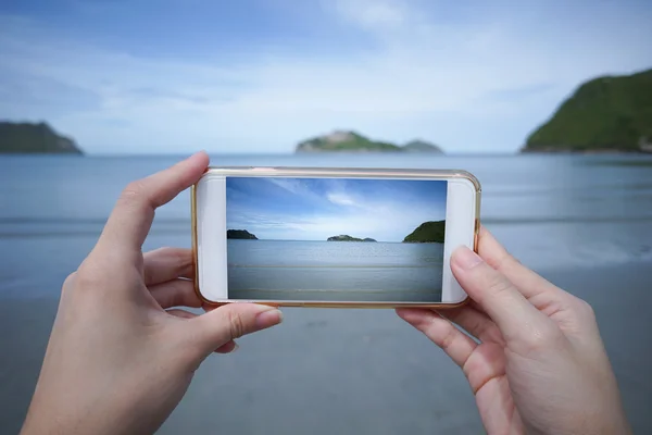 Woman use smart phone take a photo of the sea in Prachuapkhirikhan ,thailand