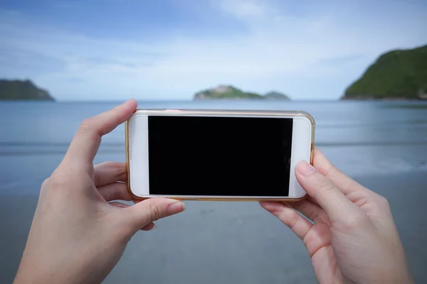 Woman use smart phone take a photo of the sea ,isolate black monitor