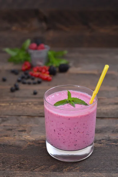 Milk shake with berries top view smoothie with mint on a rustic table