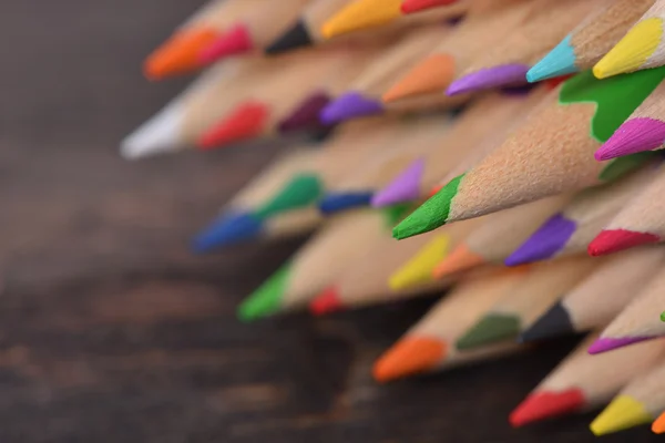 Mixed colored pencils tips on wenge wood table