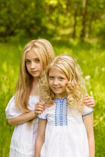Two young girls relaxing on nature in summer