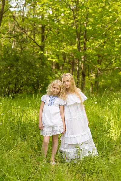 Two young girls relaxing on nature in summer