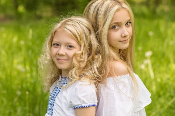 Two young girls relaxing on nature in summer