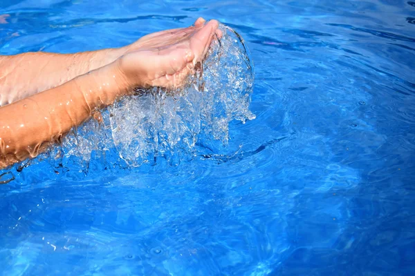 Above the pool of human two hands overflowing water