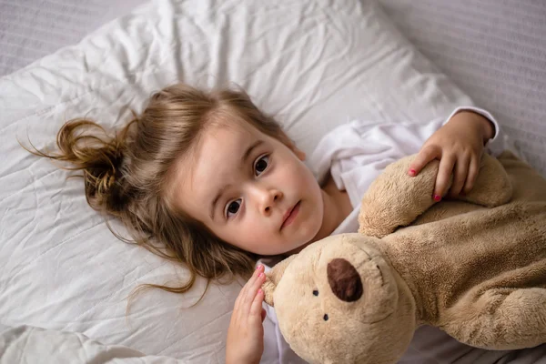 Little girl in bed with soft toy the emotions of a child