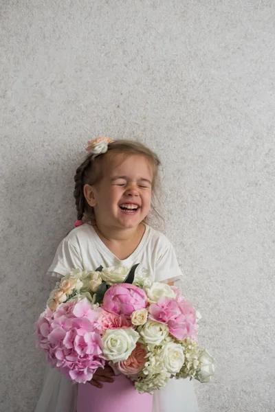 Little girl with a big bouquet of fresh flowers