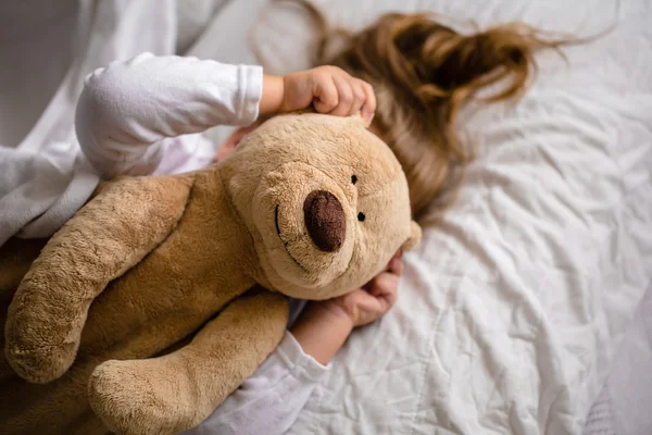 Little girl in bed with soft toy the emotions of a child