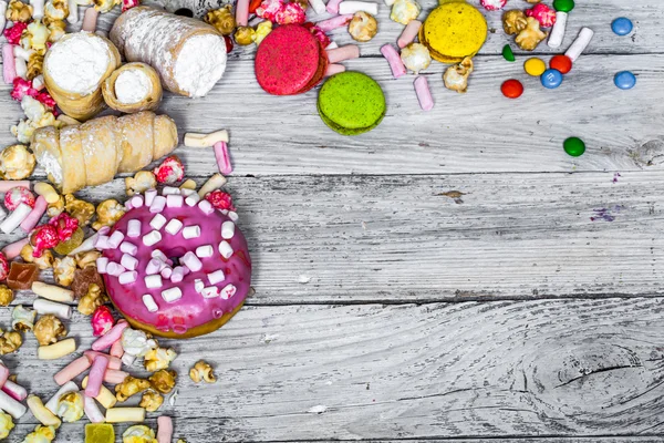 Big beautiful pink box with sweets on wooden background