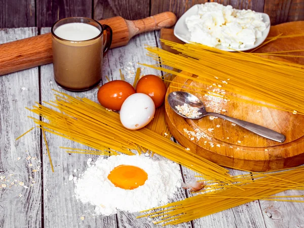 Cooking spaghetti on a wooden background milk eggs