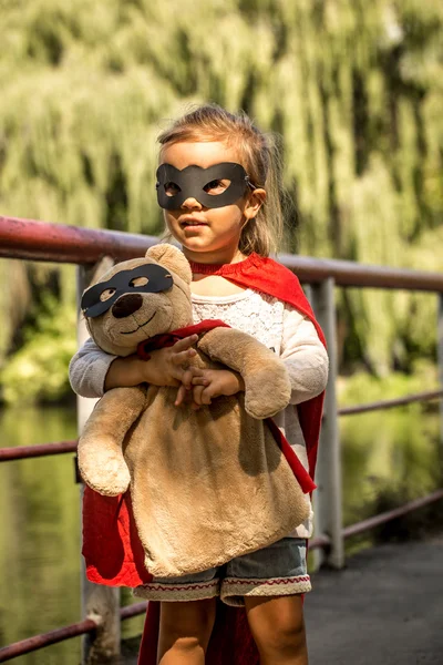 Beautiful little girl in the image of a super hero, playing