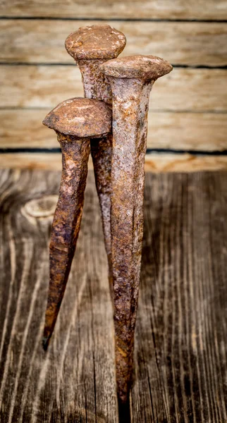 Very old large nails on a beautiful wooden background, rusty