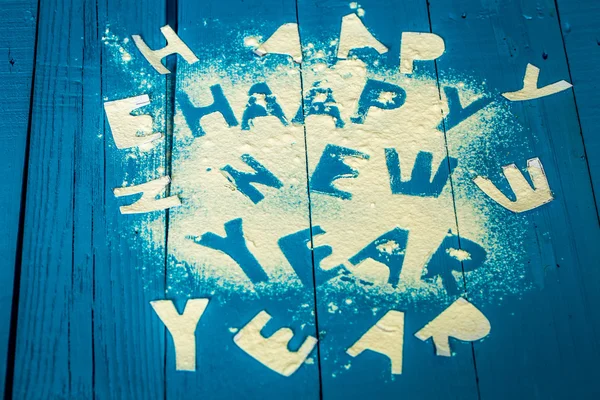 Text happy new year on the blue wood background