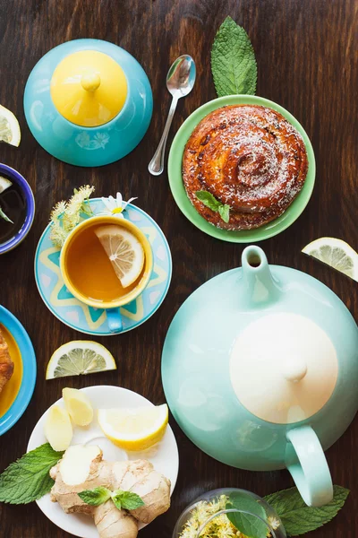 Tea set: Green tea with lemon and mint and baked goods with a crispy crust on the wooden background