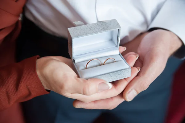 In the hands of the newlyweds rings in a box