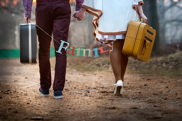 Close-up of a pair of newlyweds walking with suitcases