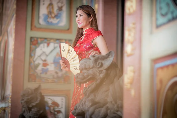 Asian Chinese woman in Traditional Chinese holding blow