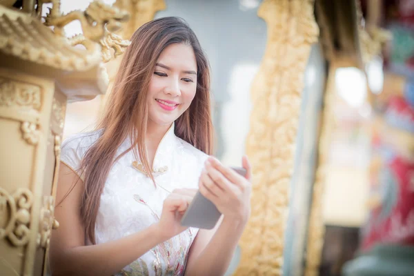 Asian Chinese woman in Traditional Chinese and hold telephone