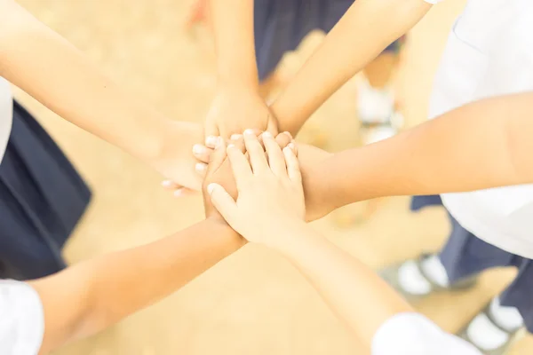 Children making pile of hands ,teamwork concept