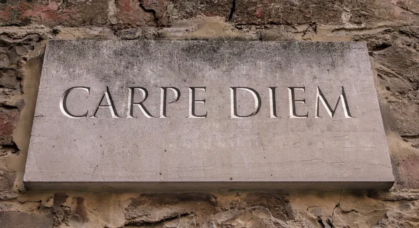 Carpe diem. A Latin phrase that means seize the day. By Horace. Engraved text.
