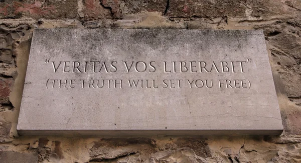Veritas vos liberabit. A Latin phrase meaning The truth will set you free. Engraved text.