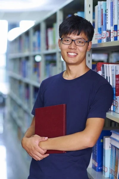 Young male college student looking at camera smile in the librar
