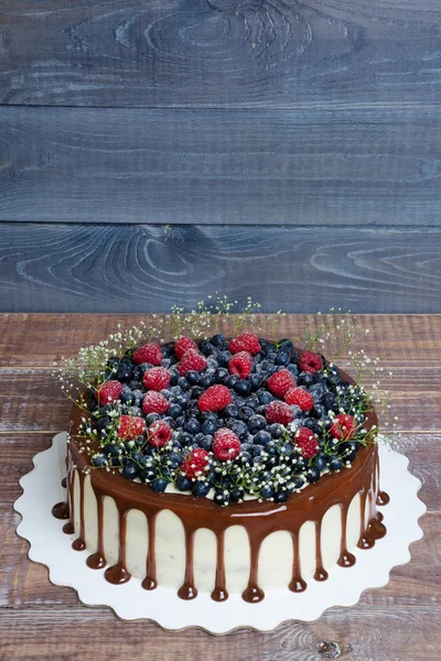 Color drip cake with blueberries and raspberries